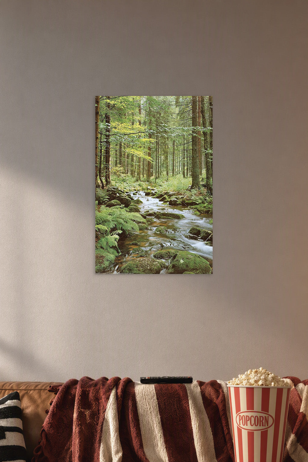 Wall Poster Forest Creek in a cozy movie room above a brown sofa with popcorn.