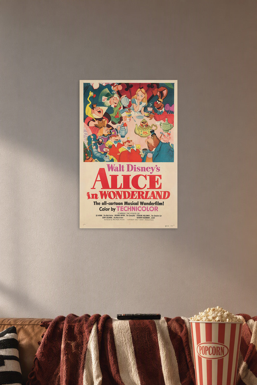 Walt Disney's Alice in Wonderland Movie Poster in a cozy movie room above a brown sofa with popcorn.