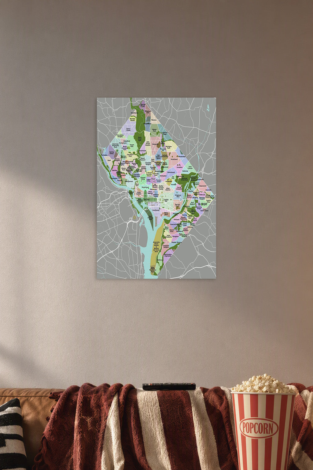 Washington D.C. Neighborhood Map in a cozy movie room above a brown sofa with popcorn.