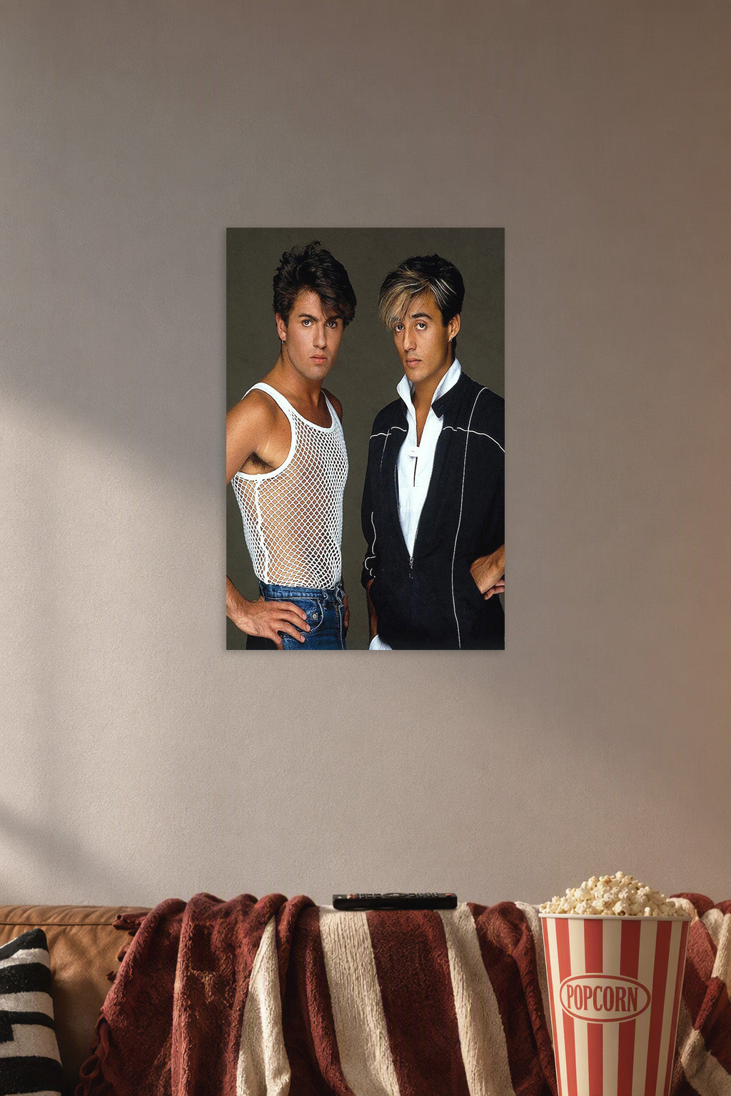 Wham! George Michael and Andrew Ridgeley in a cozy movie room above a brown sofa with popcorn.