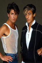 Wham! poster features George Michael and Andrew Ridgeley posing against a dark gray backdrop in distinctive 1980s outfits.