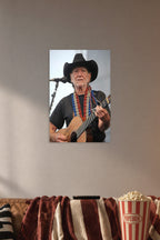 Willie Nelson in a cozy movie room above a brown sofa with popcorn.