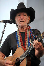 Willie Nelson poster features the country singer in a black cowboy hat, playing an acoustic guitar beside a microphone.