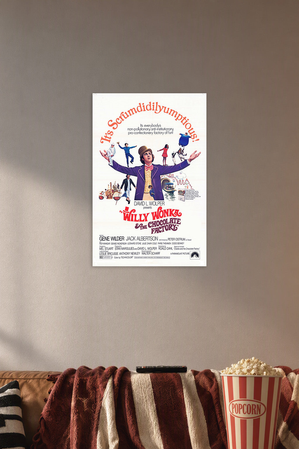 Willy Wonka & the Chocolate Factory in a cozy movie room above a brown sofa with popcorn.