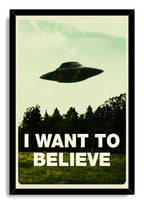 I Want To Believe framed wall art print with a black border, a shadowy UFO over a tree line, and bold white lettering.