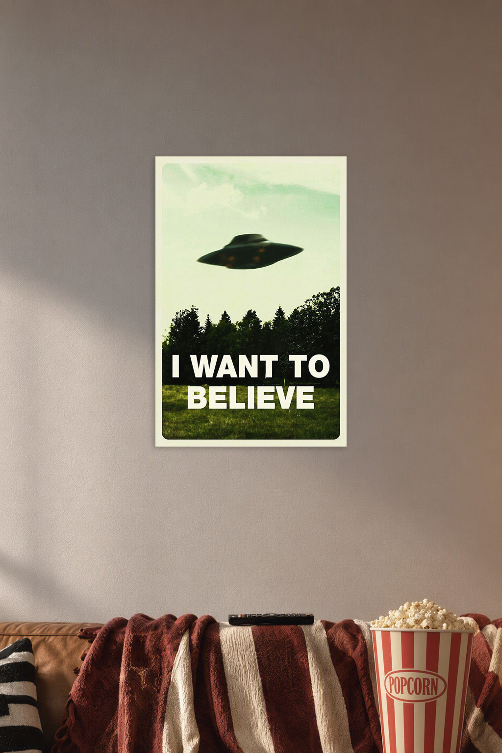 X-Files 'I Want To Believe' UFO in a cozy movie room above a brown sofa with popcorn.