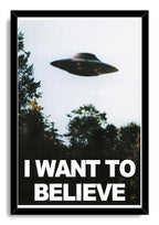 X-Files UFO wall art print in a black frame, with a shadowy saucer over a forest and large white “I WANT TO BELIEVE” lettering.