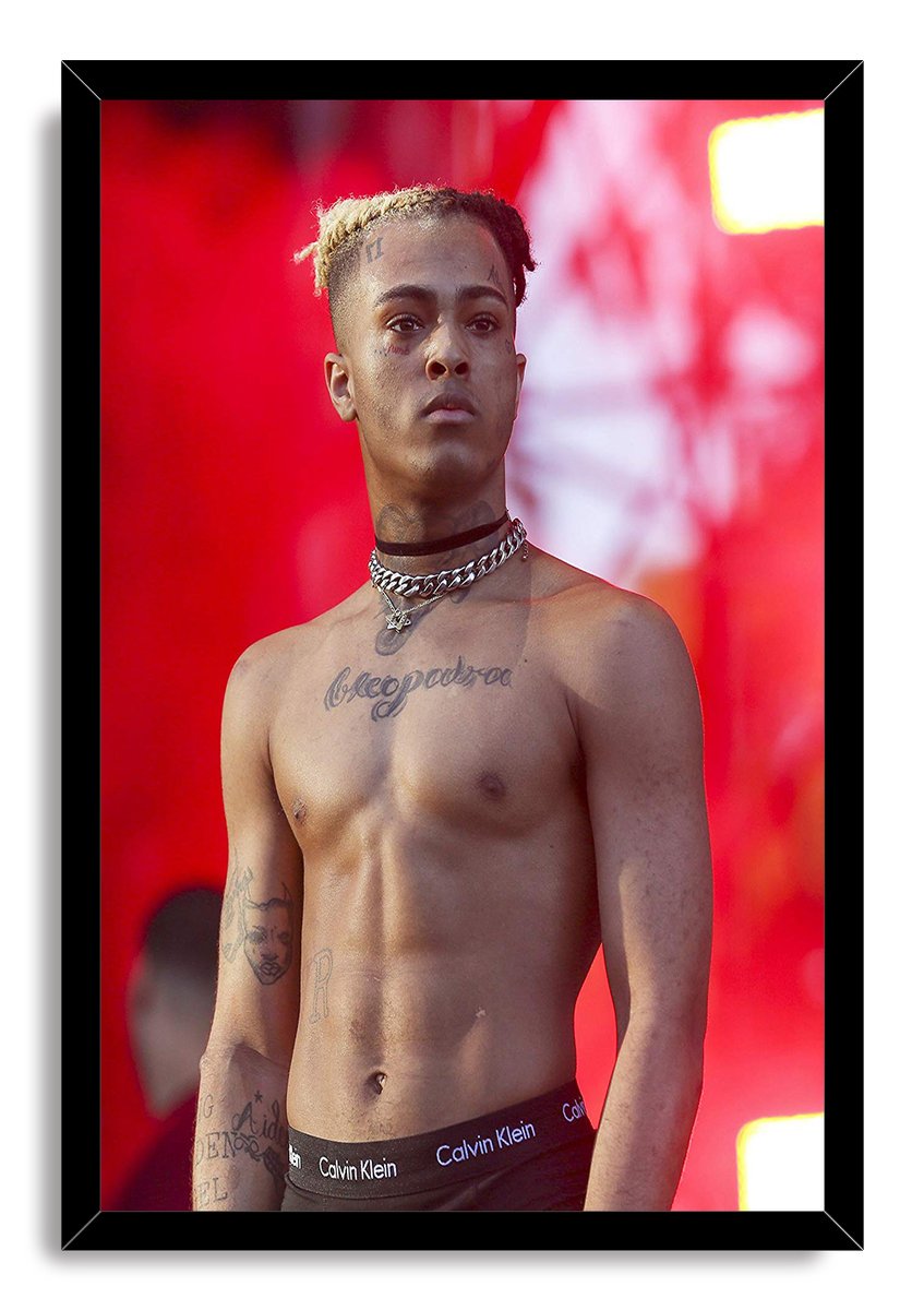 XXXTentacion framed wall art print portraying the shirtless, tattooed rapper with chains against red stage lighting.