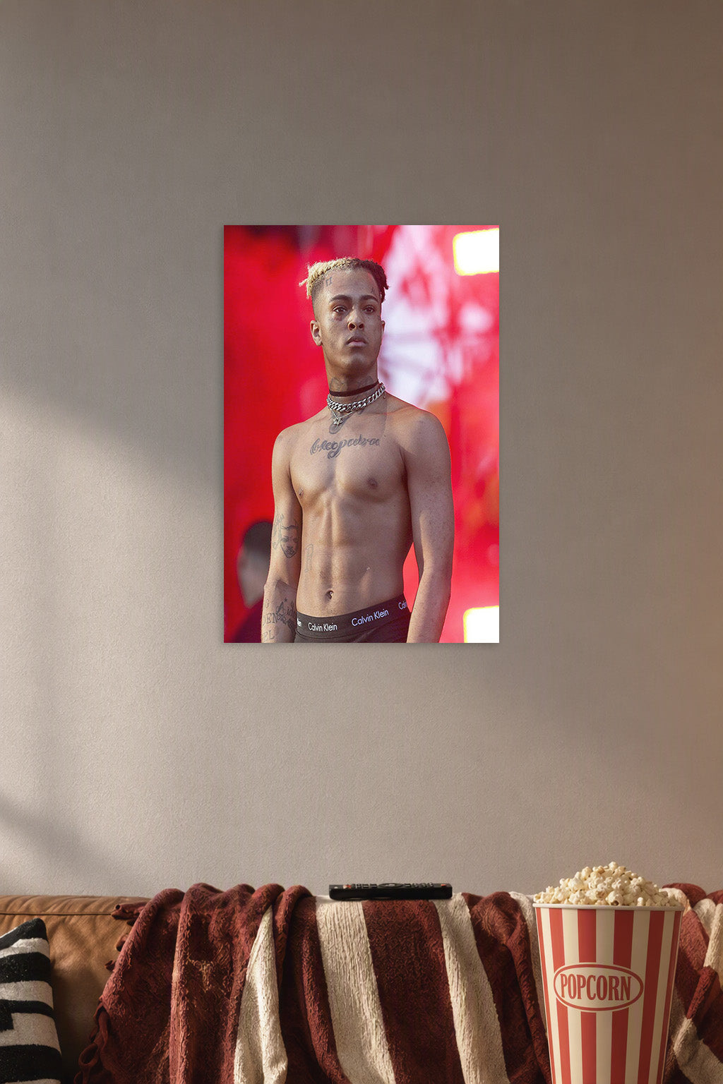 XXXTentacion in a cozy movie room above a brown sofa with popcorn.