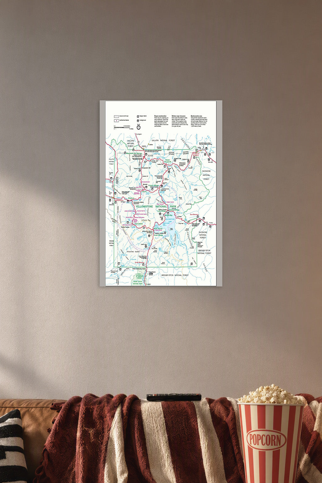 Yellowstone National Park Map in a cozy movie room above a brown sofa with popcorn.