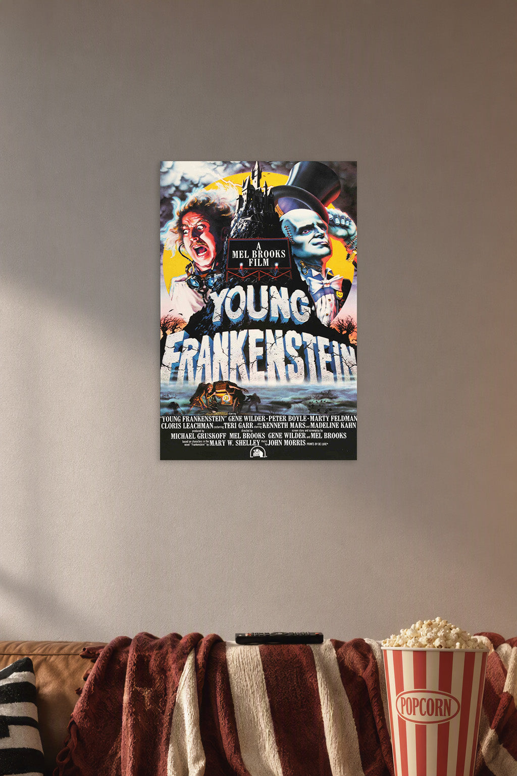 Young Frankenstein Movie in a cozy movie room above a brown sofa with popcorn.