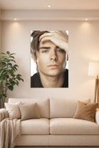 Zac Efron in a bright living room above a beige sofa.