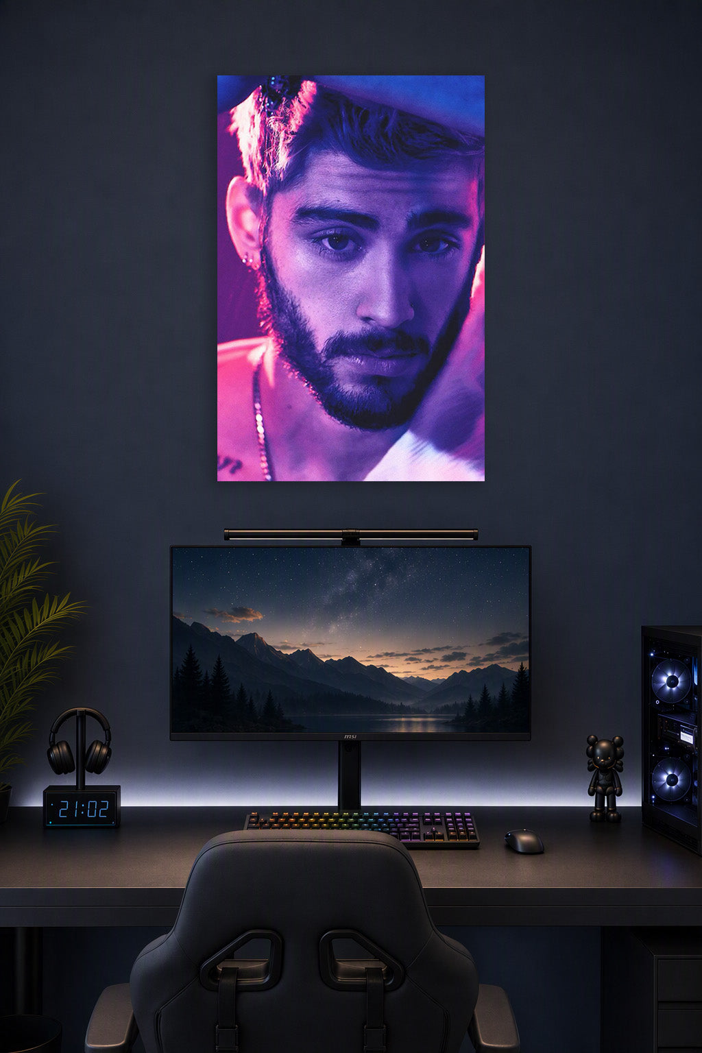 Zayn Malik in a gaming desk setup above a monitor.