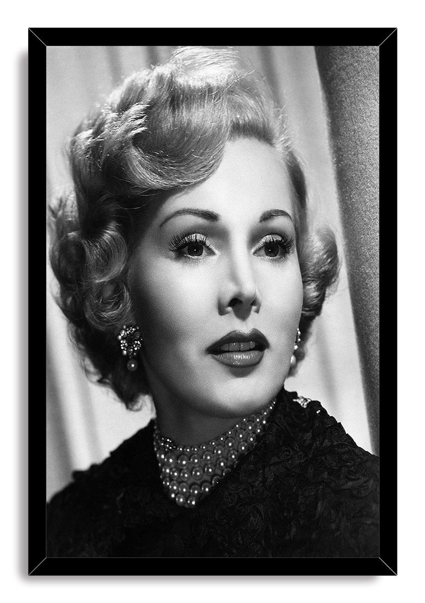 Zsa Zsa Gabor framed wall art print displays a monochrome portrait of the actress in a black frame, wearing pearls and jeweled earrings.